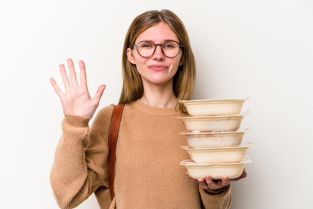 Donna giovane studente in possesso di un toppers isolato su sfondo bianco sorridente allegro che mostra il numero cinque con le dita