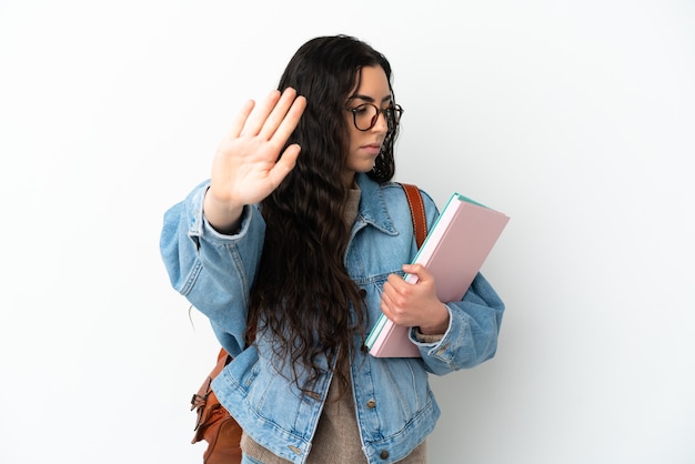 Donna giovane studente isolata su sfondo bianco che fa gesto di arresto e deluso