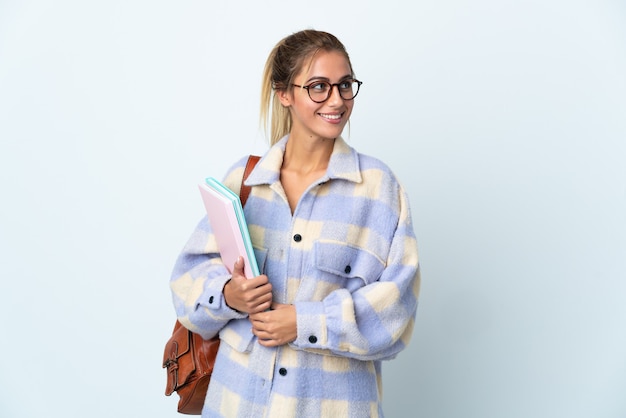 Donna giovane studente isolata su sfondo bianco guardando al lato