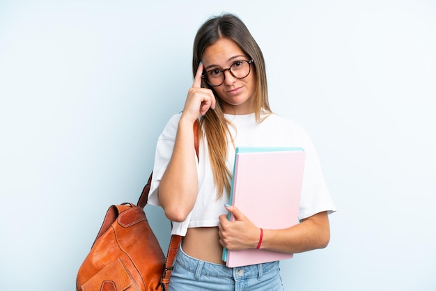 Donna giovane studente isolata su sfondo blu pensando un'idea