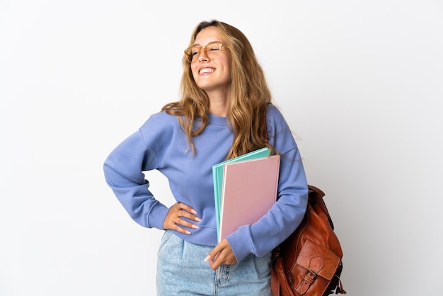 Donna giovane studente isolata sul muro bianco in posa con le braccia al fianco e sorridente