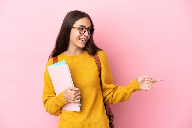 Donna giovane studente su sfondo isolato puntare il dito di lato e presentare un prodotto