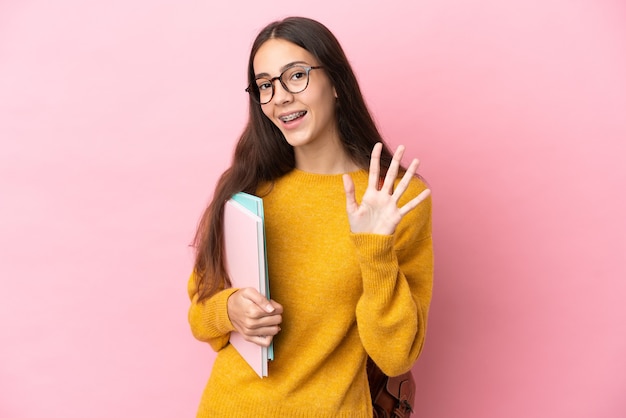 Donna giovane studente su sfondo isolato salutando con la mano con espressione felice happy