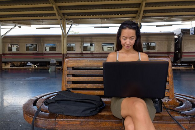 Donna giovane turista seduto e utilizzando il computer portatile