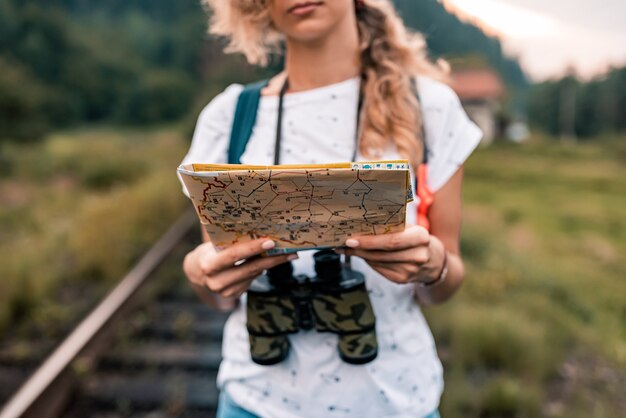 Donna giovane viaggiatore con una mappa su una ferrovia