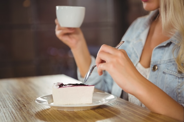 Donna godendo torta e caffè