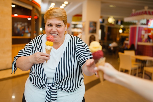 Donna grassa che compra gelati, ristorante fastfood