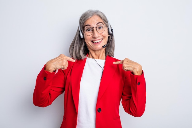 Donna graziosa anziana che si sente felice e indica se stessa con un'eccitazione. concetto di telemarketing