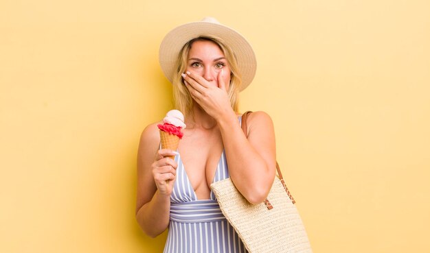 Donna graziosa bionda che copre la bocca con le mani con uno scioccato