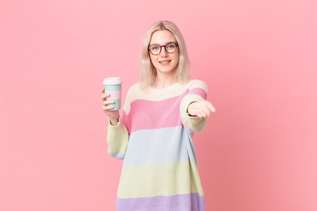 Donna graziosa bionda che sorride felicemente con amichevole e offrendo e mostrando un concetto. concetto di caffè