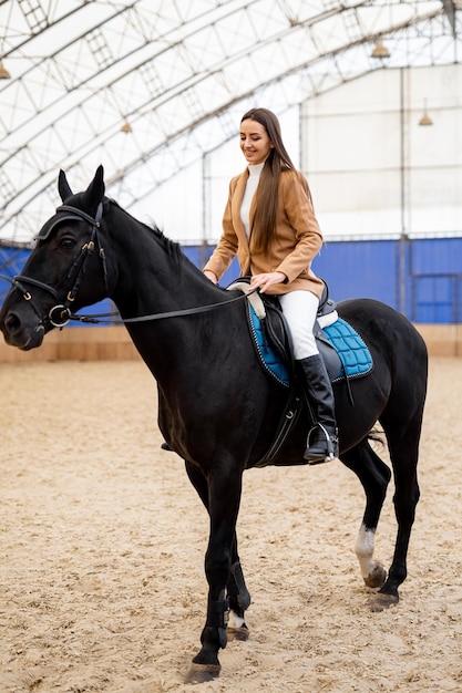 Donna graziosa che guida sul cavallo Signora all'aperto del cavaliere di cavallo