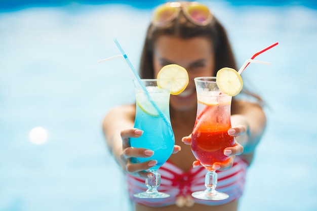 Donna graziosa che ha un'abbronzatura naturale vicino alla piscina.