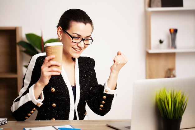 Donna graziosa che lavora al computer portatile nell'ufficio