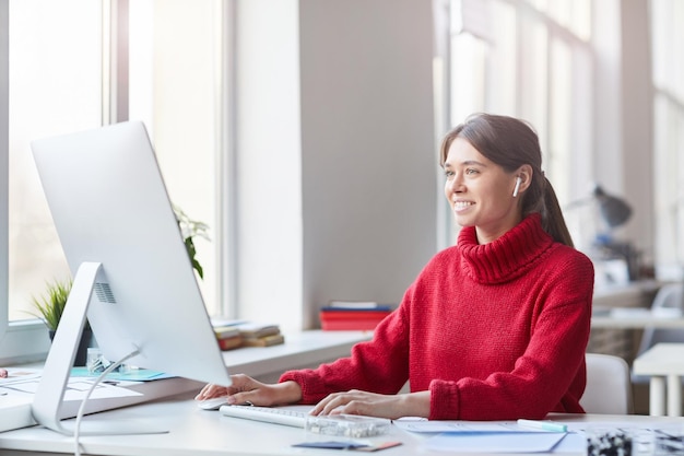 Donna graziosa che lavora con il computer moderno