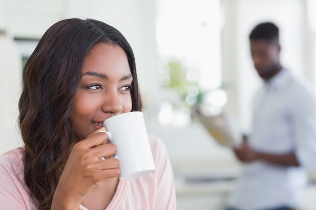 Donna graziosa che mangia tazza di caffè