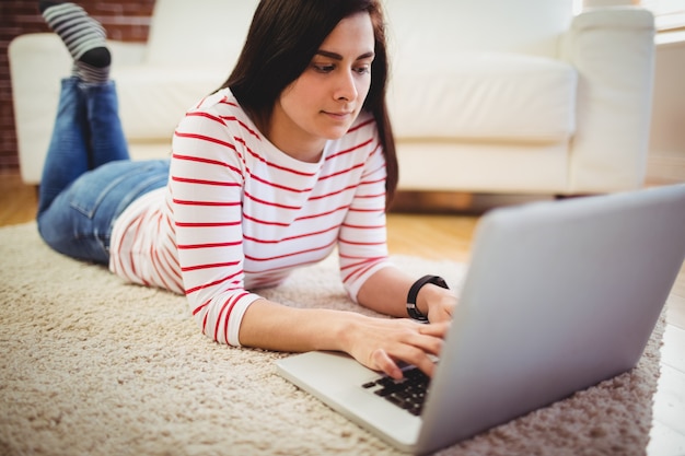 Donna graziosa che per mezzo del computer portatile