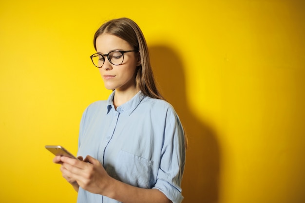 Donna graziosa che per mezzo di uno smartphone