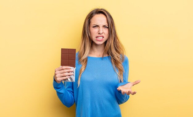 Donna graziosa che sembra concetto di cioccolato infastidito e frustrato arrabbiato