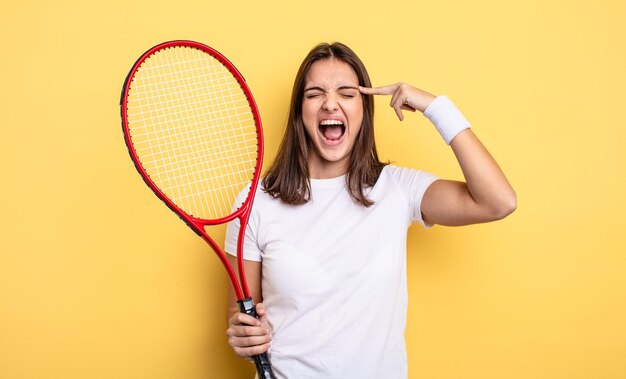 Donna graziosa che sembra gesto di suicidio infelice e stressato facendo segno di pistola concetto di giocatore di tennis