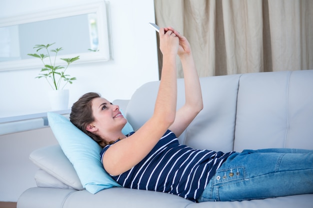 Donna graziosa che si trova sullo strato che prende un selfie