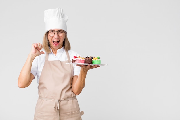 Donna graziosa del panettiere di medio evo con le torte