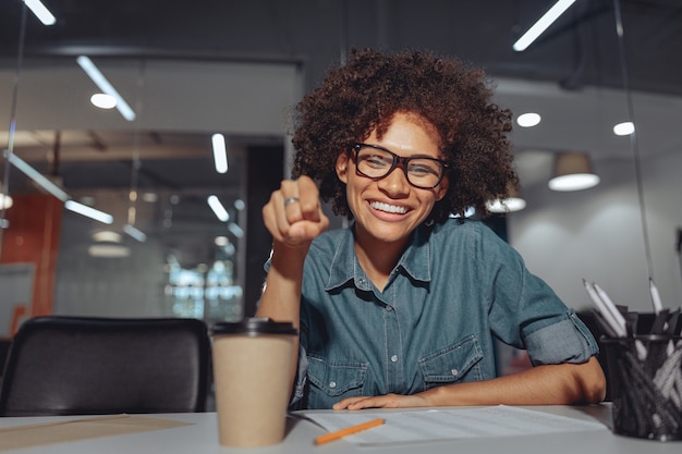 Donna graziosa e amichevole che usa il linguaggio dei segni in ufficio