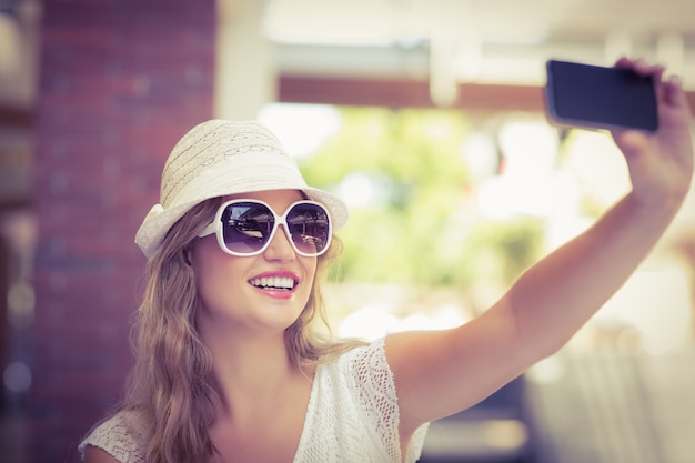 Donna graziosa hipster prendendo un selfie