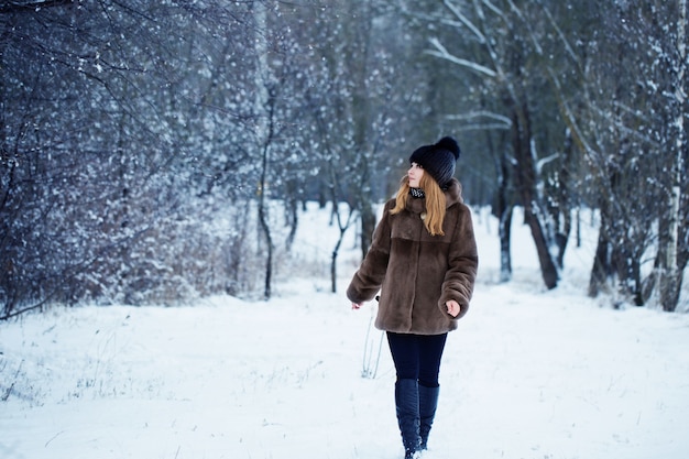 Donna graziosa in un parco di inverno