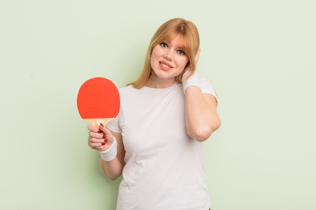 Donna graziosa rossa che si sente stressata o spaventata con le mani sul concetto di ping pong della testa