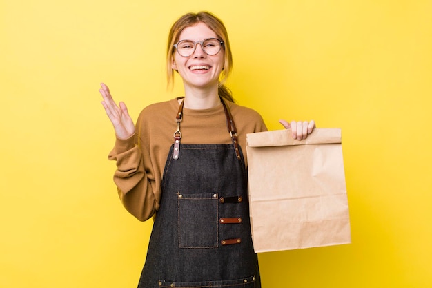 Donna graziosa testa rossa che si sente felice sorpresa realizzando una soluzione o un'idea consegna take away concept