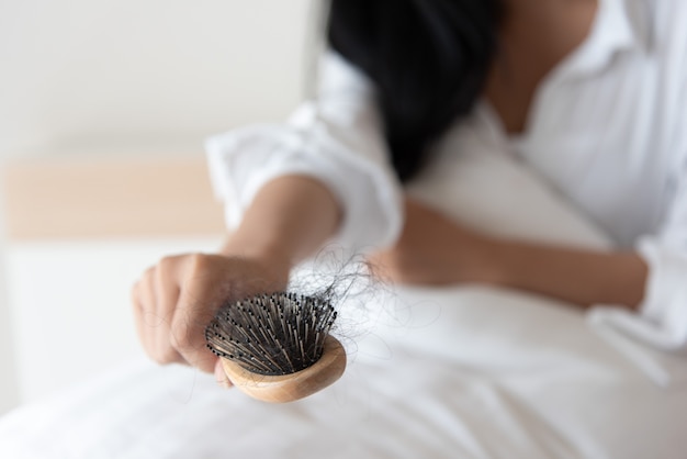 donna guardando i suoi capelli per problema di perdita di capelli