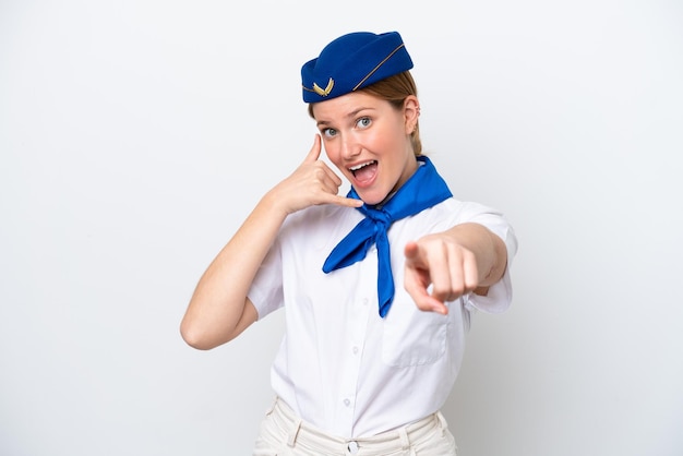 Donna hostess dell'aeroplano isolata su sfondo bianco che fa il gesto del telefono e indica la parte anteriore