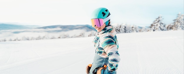 Donna in abbigliamento da sci con casco e occhiali da sci in testa con bastoncini da sci Meteo invernale sulle piste Montagna e vista panoramica Sciatore alpino Sport invernali Scialpinismo