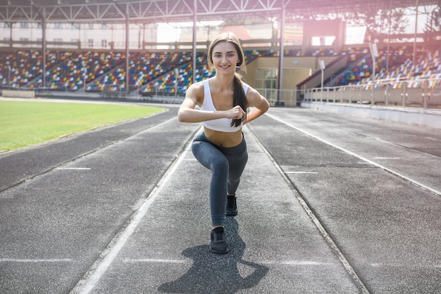 Donna in abiti sportivi facendo corsa mattutina allo stadio