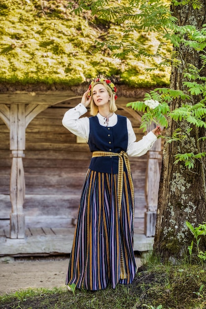 Donna in abiti tradizionali in posa sulla natura nel villaggio