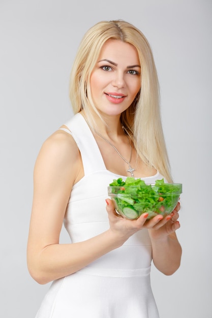 Donna in abito bianco con insalata fresca