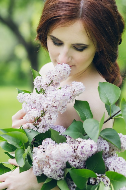 Donna in abito bianco lungo nel giardino estivo