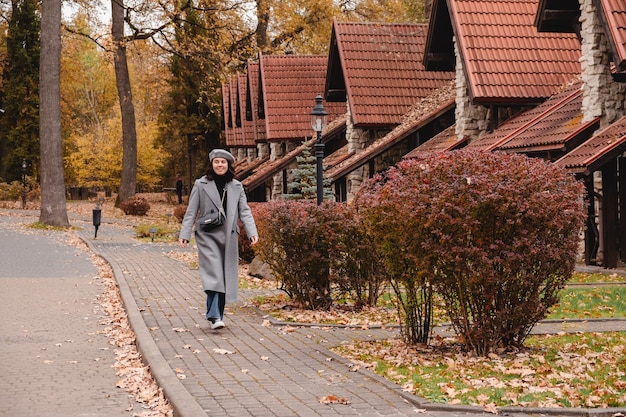 donna in abito d'autunno che cammina per lo spazio di copia di strada