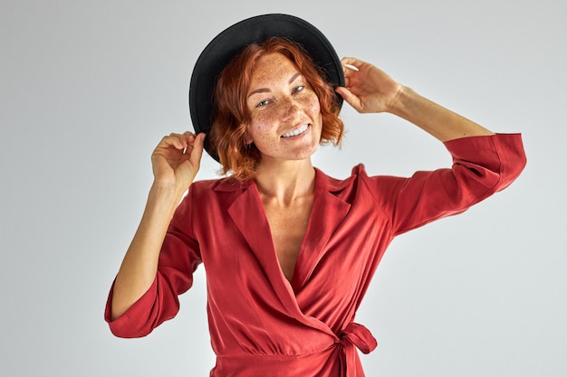 donna in abito elegante e cappello che propone alla macchina fotografica, le persone e il concetto di lifestyle. donna carina ha