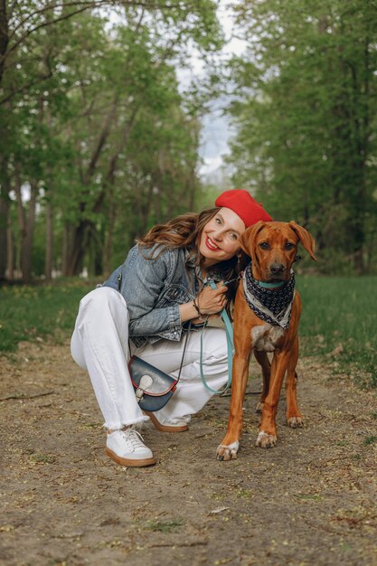 donna in abito francese che abbraccia il fedele cane Rhodesian Ridgeback