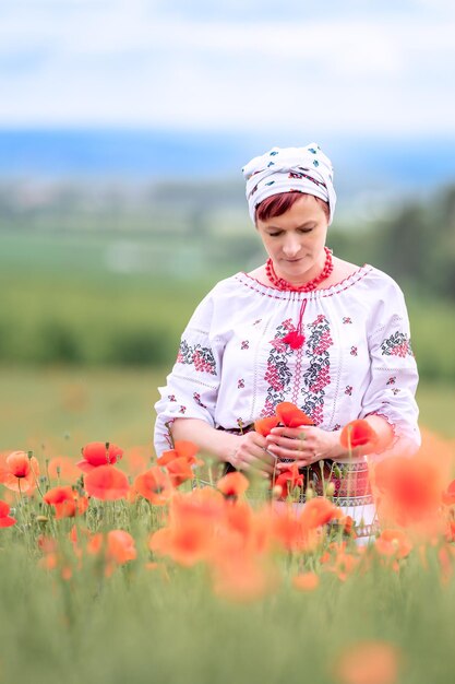 Donna in abito nazionale ucraino su un campo di papaveri in fiore