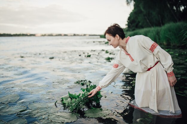 Donna in abito tradizionale in piedi nel fiume