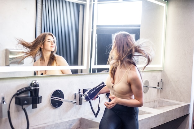 Donna in bagno che asciuga i capelli