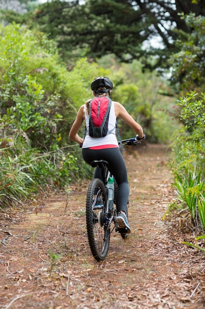 Donna in bicicletta in campagna