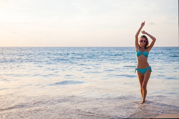 Donna in bikini che balla in mare