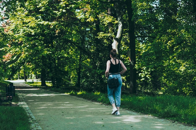 Donna in blue jeans nel parco verde della città