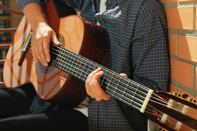 Donna in camicia che suona la chitarra classica