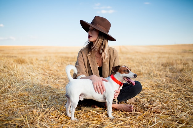 Donna in cappello con il cane sul campo