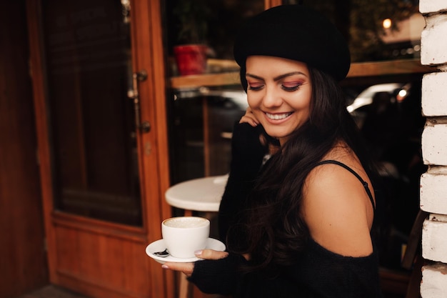 Donna in cappello con una tazza di caffè