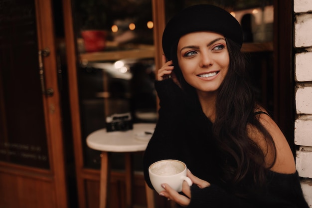 Donna in cappello con una tazza di caffè